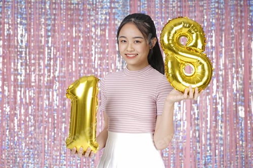 Visualização: Jovem adolescente asiática, linda e alegre, com balão dourado para festa, em rosa cintilante