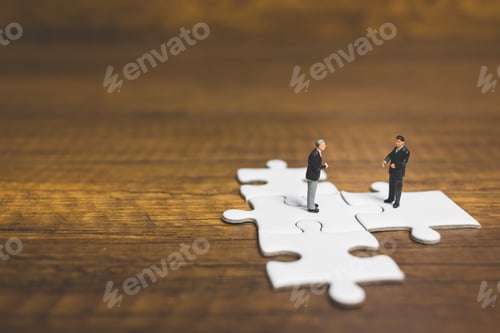 Preview: Miniature People: Businessman Standing On Jigsaw With Wooden Background : Business Concept.