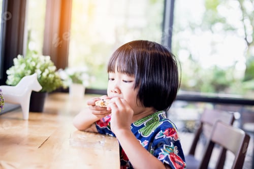 Preview: Portrait Of Little Girl Eating Cookies In The Kitchen