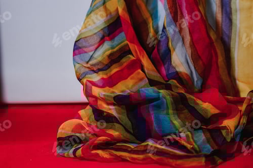 Preview: Colorful Striped Fabric Draped over Red Surface