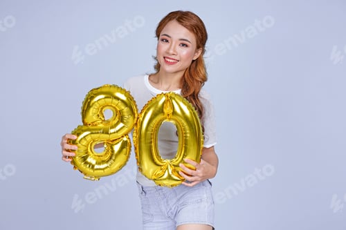 Vista previa: Joven asiática atractiva y hermosa joven sosteniendo un número de globo de aluminio metálico