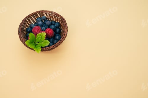 Preview: A Top View Of Blueberries Raspberries And Leaves In A Basket