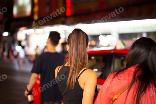 Preview: People Walking on a Street at Night