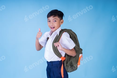 Preview: An Ecstatic Asian School Boy Wearing White Shirt, Blue Pants And Backpack Over Blue Background