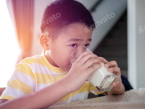 Preview: Little Boy Drinking Milk At Table In Kitchen