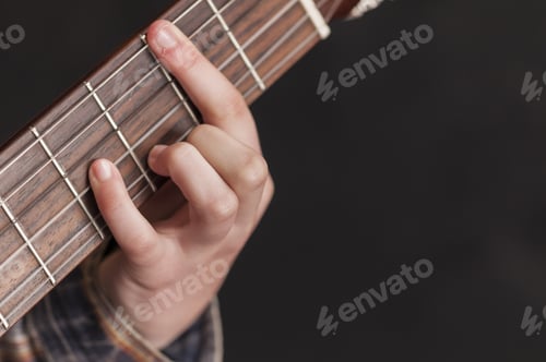 Preview: A Closeup Shot Of A Girl'S Hand Playing Guitar On A Dark Background With Copyspace
