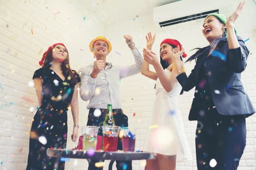 Visualização: Pessoas felizes do grupo empresarial com chapéu de Papai Noel se divertindo na festa de Natal de celebridades.