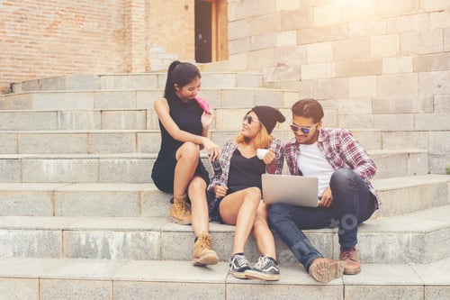 Preview: Group Of Hipster Students Sitting On A Staircase Talking And Relaxing After School Together.