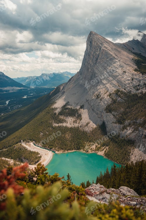 Preview: A Vertical Shot Of Mesmerizing Mountain Scenery With A Bright Green Lake In Canmore, Alberta