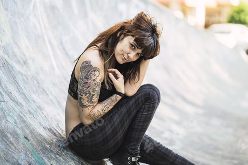 Preview: A Young Attractive Caucasian Female With Tattoos Sitting On A Skating Ramp