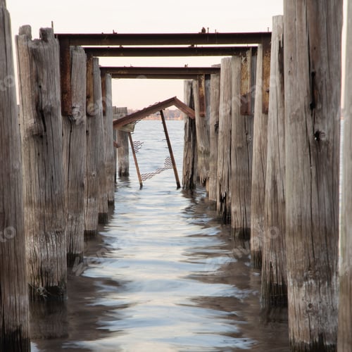 Preview: A Wooden Pier With Weathered Columns In The Sea On Background Of The Sky
