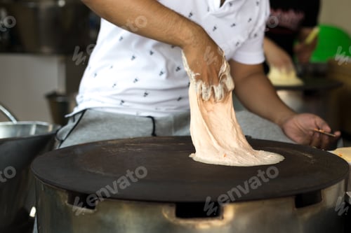 Preview: Man Making A Roti Dough Sheet On A Hot Pan