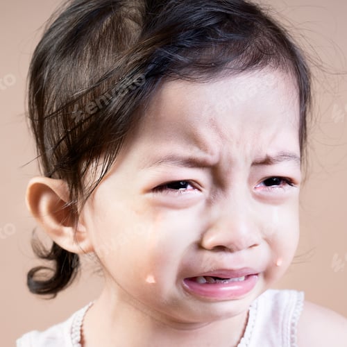 Preview: Close Up Portrait Of An Emotional Asian Girl Crying On A Brown Background. Square Format.