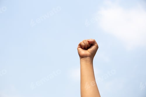 Preview: Woman Arm With Fist Raised In The Air.
