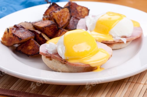 Preview: A Closeup Shot Of Eggs Benedict With Farm Fresh Eggs And Ham And Fried Potatoes