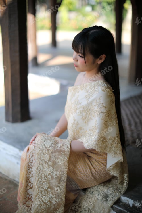 Preview: Portrait Of Thai Female With Traditional Thai Dress Sitting With Temple Background