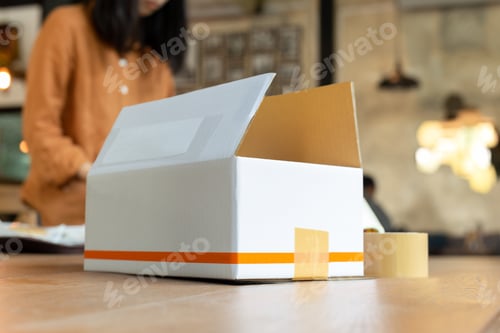 Preview: Startup Small Business Woman Owner Packing Cardboard Box At Workplace.