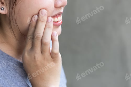 Preview: Asian Teenage Woman With Toothache In Gray Background