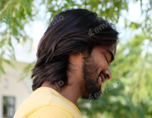 Preview: A Young Handsome Bearded Indian Male With Long Hair Standing Outdoors And Smiling