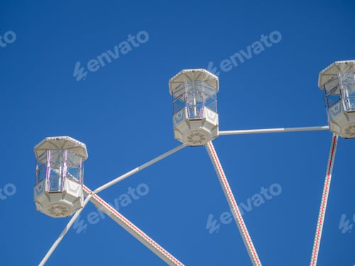 Preview: The White Cabs Of A Ferris Wheel On A Blue Background