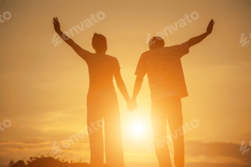 Preview: Young Couple Hand In Hand At Sunset On The Mountain