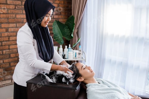 Preview: Hairdresser Washing Hair of Client in Beauty Salon
