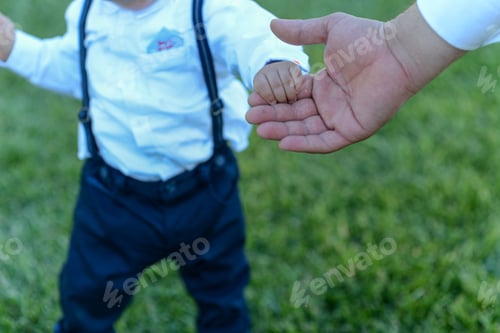 Preview: A Boy Kid Holding The Hand Of His Father