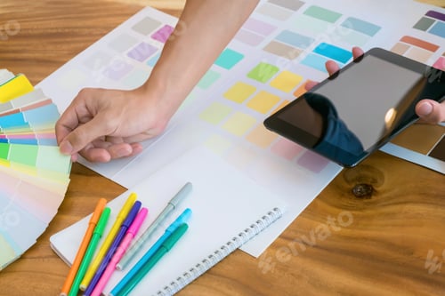 Preview: Creative Business Woman Using Tablet And Working On Colour Charts On Desk At A Modern Office