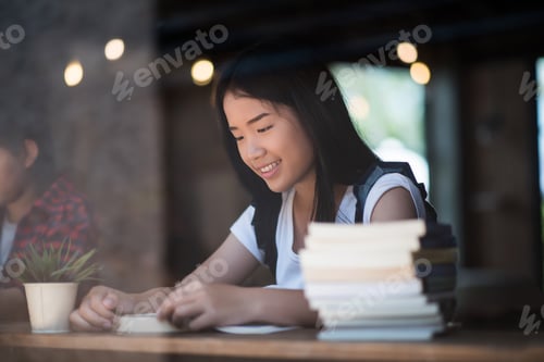 Preview: Young Woman Reading Book Sitting Indoor In Urban Cafe.