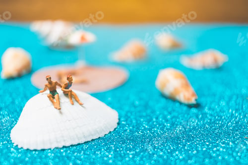 Preview: Miniature People Wearing Swimsuit Relaxing On A Seashell With Blue Glitter Background