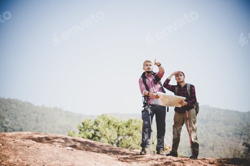 Preview: Young Tourist Couple Traveling On Holidays In Mountain Looking At Map In Search Of Attractions