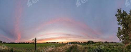 Preview: A Beautiful View Of The Sunset Over A Green Landscape