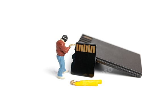 Preview: Miniature People Technician Fixing Pile Of Sd Cards On White Background With Copy Space.