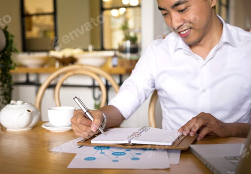 Preview: Asian Businessman Using His Smart Phone, Computer In His Office