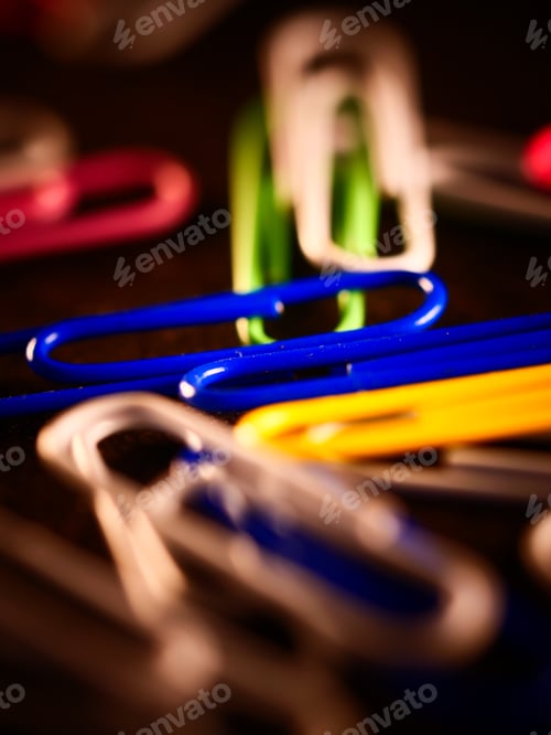 Preview: A Vertical Selective Focus Shot Of A Pile Of Colorful Paperclips With Bright Light Shining On Them