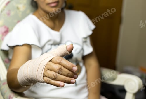 Preview: Pain Concept Woman Sitting On A Chair With Splint Broken Bone On Her Hand