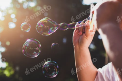 Preview: Blurred Concept People Blowing Bubble Through Bubble Ring In Sunlight