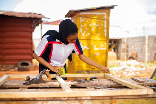 Preview: A Female African Professional Carpenter Smiling As She Takes A Measurement Of Wood