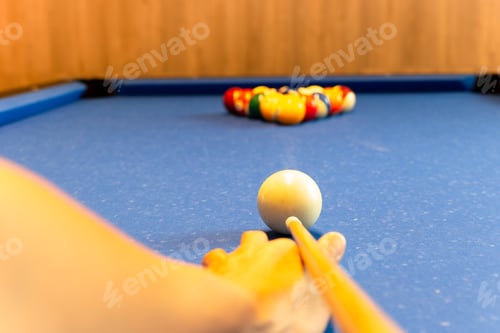 Preview: Player Striped Dress Holds A Cue Over Pool Table With Blurred Billiard Balls.