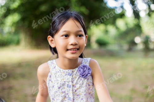 Visualização: Garotinha asiática fofa em pé entre o dia do sol do campo de flores roxas. Liberdade desfrutando com