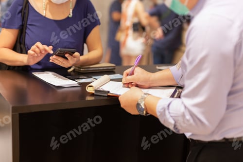 Preview: Seller Writing On Contract Paper With Woman Customer At Shop Counter