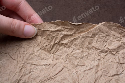 Preview: A Closeup Shot Of Fingers Holding A Crumpled Paper