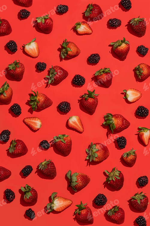 Vista previa: A Vertical High Angle Shot Of Strawberries And Blackberries On A Red Background