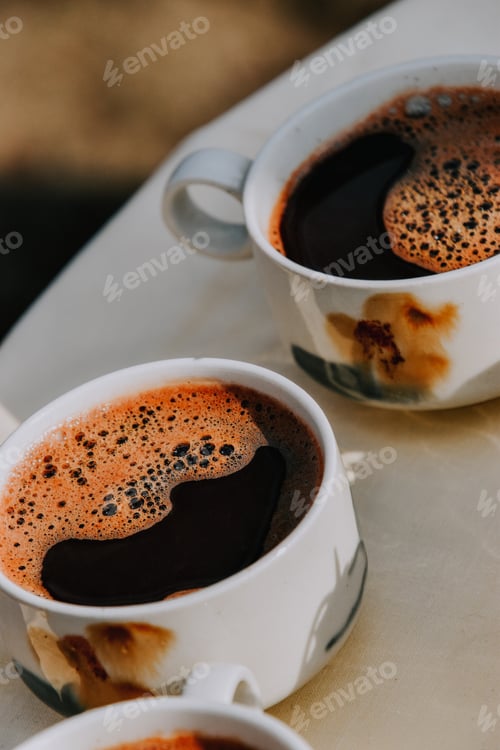 Preview: A Vertical Shot Of Two Cups Of Coffee On A Tabl