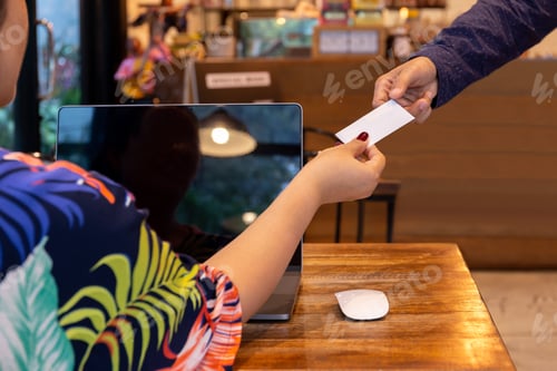 Preview: Businesswoman Handing Out Business Card To Businessman In Cafe.