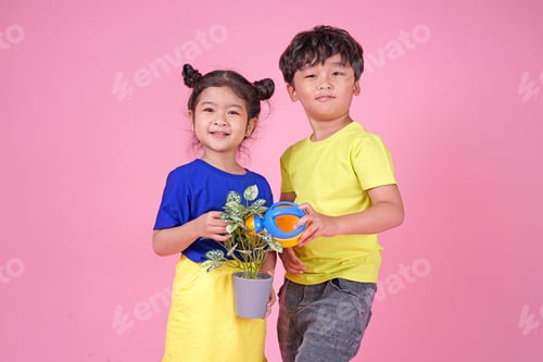Preview: Cute Asian Child Boy And Girl Planting With Plant Isolated On Pink Background