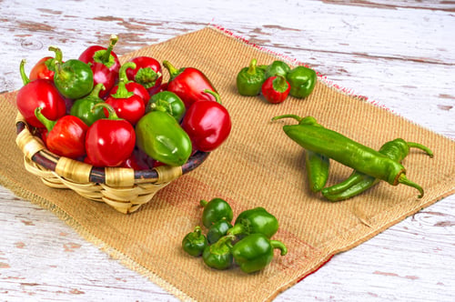Preview: A Closeup Of Piles Of Different Peppers On A Wooden Table