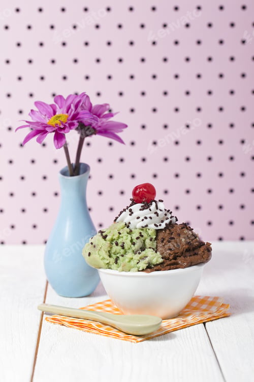 Preview: A Bowl With Mint And Chocolate Ice Cream With A Flower Vase On The Side