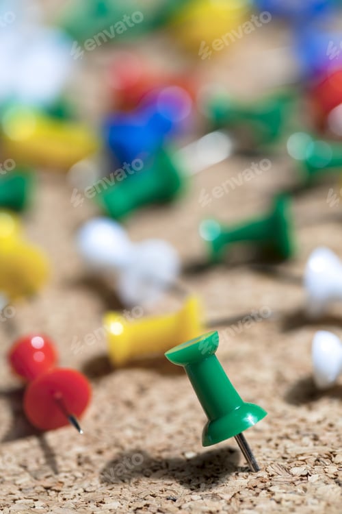 Preview: A Portrait Of Green Pushpin With Blurred Pushpins On The Background On A Wooden Cork Board