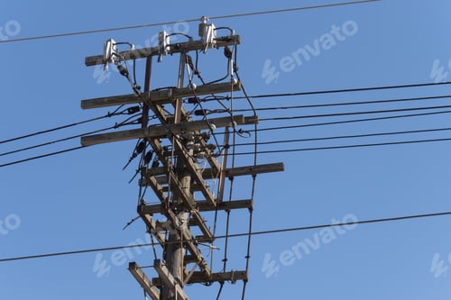 Preview: An Old Wooden Electric Power Utility Pole With A Mess Of Wires And Insulators On A Blue Sky